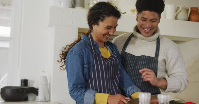Video of happy biracial couple preparing meal together