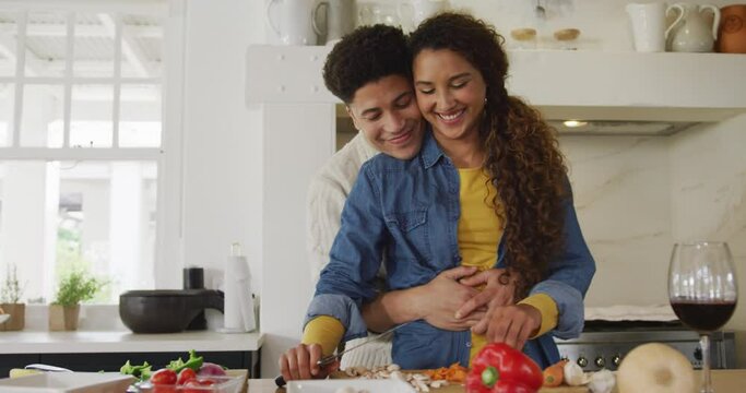 Video of happy biracial couple preparing meal together