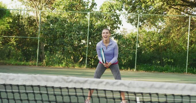 Video of happy caucasian woman playing tennis on the court
