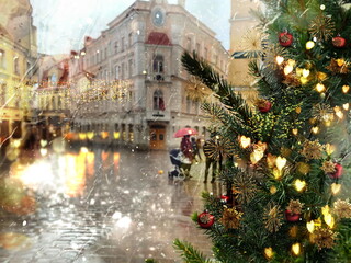 rainy Christmas  tree gold blurred light festive decoration  on  street people walking with umbrellas in medieval Tallinn old town holiday in Estonia