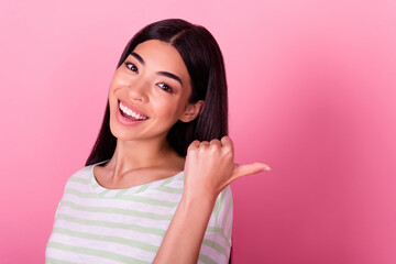 Photo of gorgeous satisfied person indicate thumb finger empty space blank isolated on pink color...