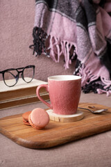 Autumn mood background with cup of cocoa, plaid on sofa. Hot drink in autumn concept