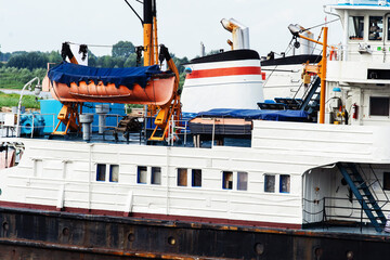 Fragment of a cargo ship with a lifeboat and decks. Close-up