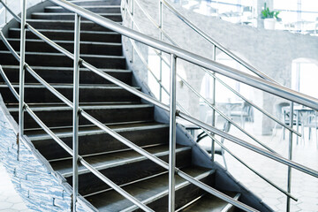 Fragment of a spiral staircase with chrome railings. Selective focus. Close up