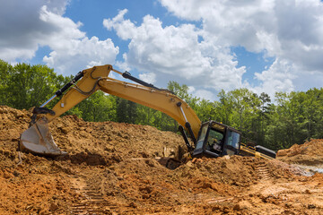 Fototapeta na wymiar On the course of construction work, the excavator became stuck in a deep pit of clay