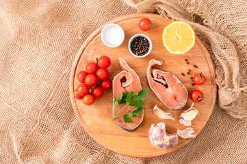  Raw red fish steaks on a wooden cutting board, ingredients for cooking. High quality photo
