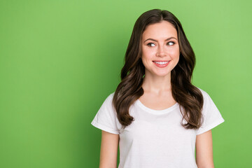 Fototapeta premium Photo of dreamy pretty young lady wear white t-shirt smiling looking empty space isolated green color background