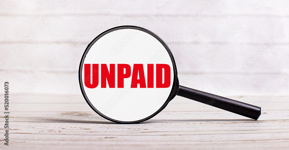 Poster the magnifying glass stands vertically on a light background with the text unpaid