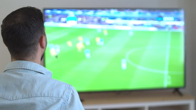 football fan dringing beer and watching world cup 2022 qatar at home