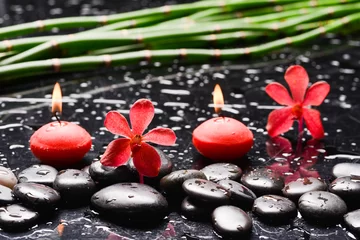 Keuken spatwand met foto Still life of with two red orchid , and zen black stones with bamboo grove on wet background  © Mee Ting