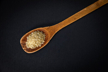 wooden spoon with salt and spices on a dark background
