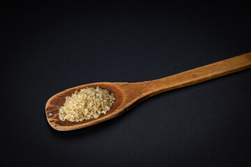 wooden spoon with salt and spices on a dark background
