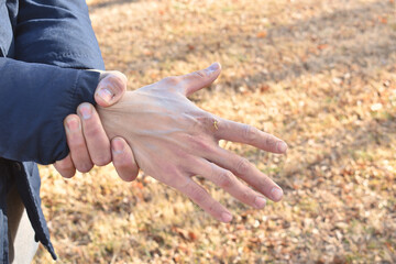 man with severe hand pain in the open air