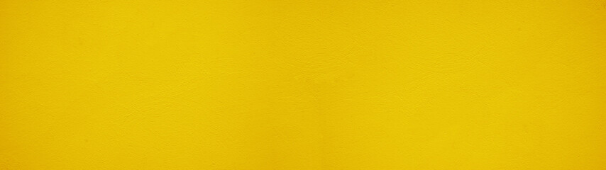 Fototapeta premium Abstract yellow colored painted rough plaster facade texture background banner panorama.