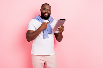 Photo of handsome wealthy businessman promote new tablet device product isolated on pink color...