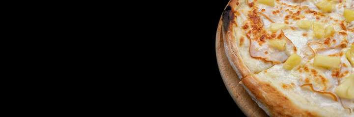 Pizza with meat, ham, pineapples, on a wooden round board on gray concrete. banner