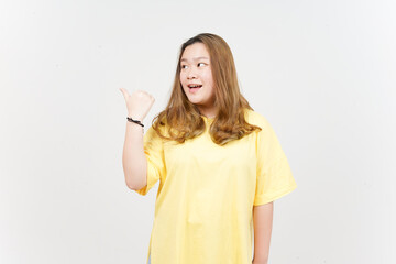 Presenting and Pointing Side Product Using Thumb of Beautiful Asian Woman wearing yellow T-Shirt