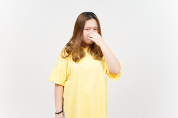 Fototapeta premium Smelling something stinky and disgusting of Beautiful Asian Woman wearing yellow T-Shirt