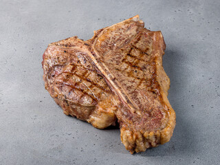 Steak T Bone, tibon steak, steak on bone on grey table macro close up