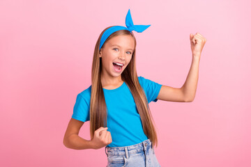 Portrait of delighted funky girl raise fists celebrate success shout yes hooray isolated on pink color background