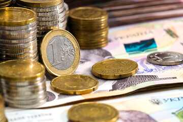 Colorful abstract background from various metal coins, Ukrainian banknotes and euro banknotes.