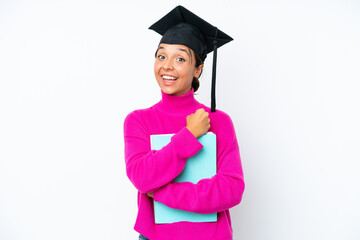 Young student hispanic woman holding a books isolated on white background celebrating a victory