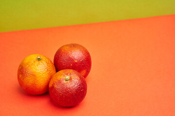 ripe juicy red sicilian oranges on orange background