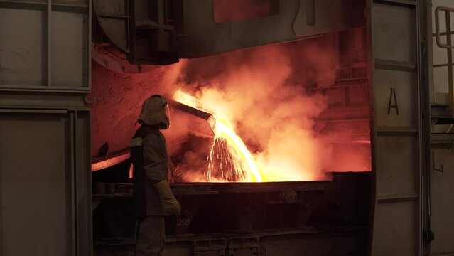 metal casting at the factory, man works near furnace