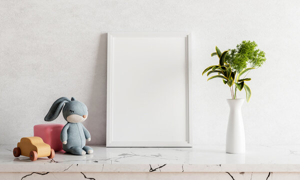 Empty photo frame mockup on white marble table with rabbit doll houseplant plant and wooden toy car. Art and interior home decoration concept. 3D illustration rendering