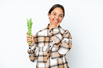 Young hispanic woman holding a green beans isolated on white background happy and smiling