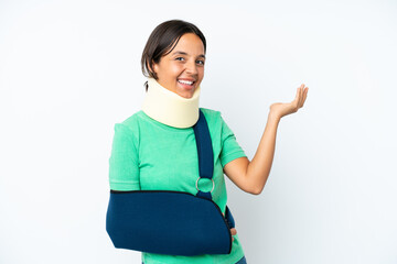 Young hispanic woman wearing a neck brace and sling isolated on white background extending hands to...