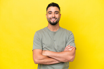 Young Arab handsome man isolated on yellow background keeping the arms crossed in frontal position