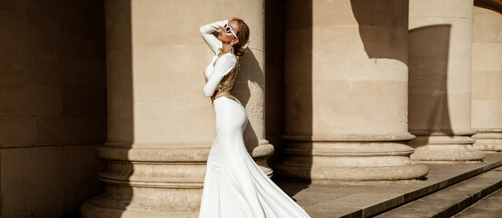 Elegant luxury fashion. Glamour, stylish elegant woman in long gown white dress is posing outdoor....