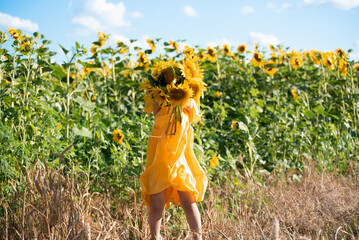 Adorable smiling kid girl of four years holding sunflowers, summer concept photo,happiness