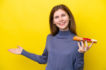 Young English woman holding sashimi isolated on yellow background extending hands to the side for inviting to come