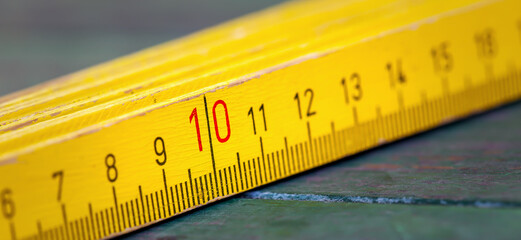 Banner of a wooden measuring retro folding ruler closeup with scale numbers. Work tool.