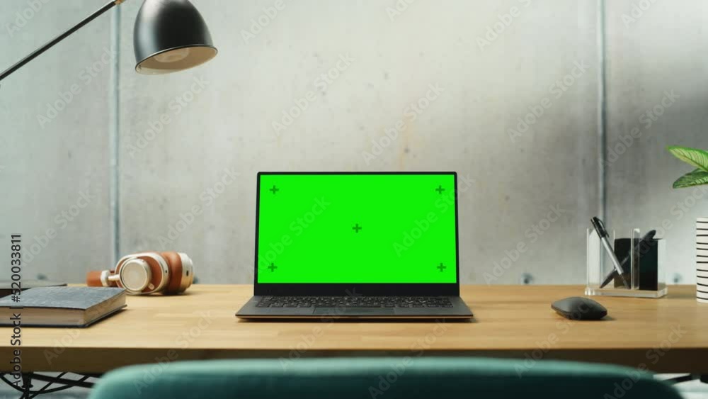 Poster laptop computer with mock up green screen display standing on a desk. efficiently minimalistic desig