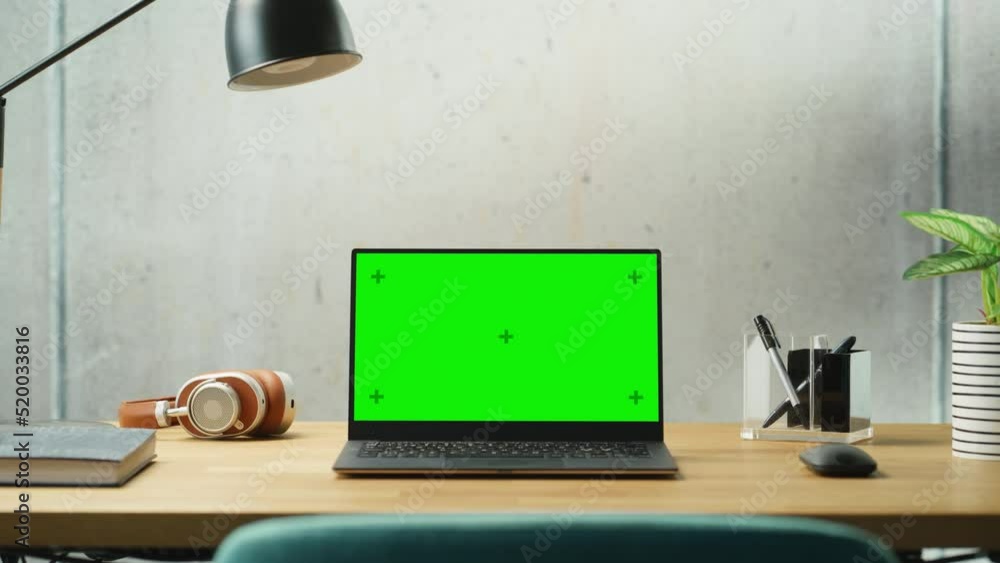 Poster laptop computer with mock up green screen display standing on a desk. efficiently minimalistic desig
