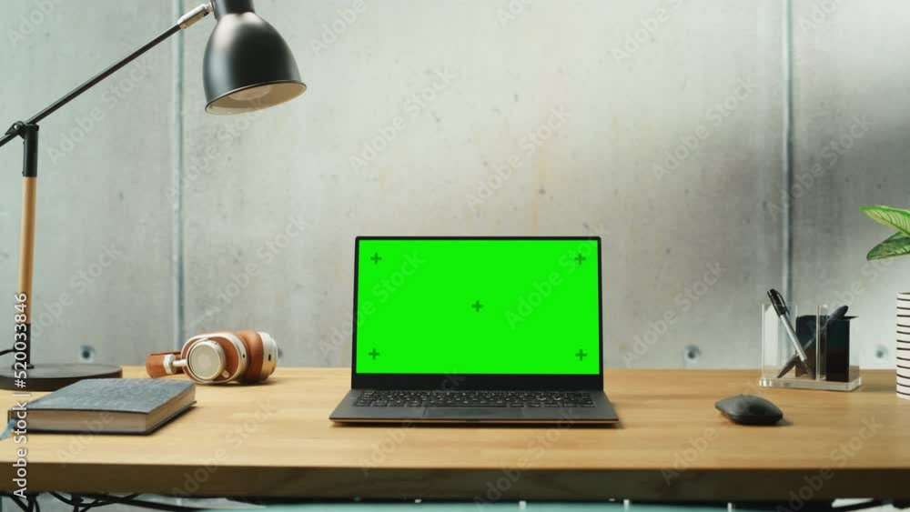 Poster laptop computer with mock up green screen display standing on a desk. efficiently minimalistic desig