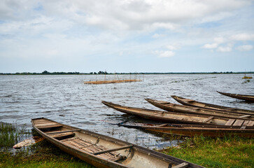 Obraz premium fishing wooden boats on the shore of the lake in southeast asia. Vietnamese nets for catching fish are placed in the lake on sticks