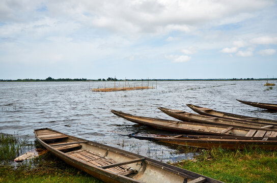 fishing wooden boats on the shore of the lake in southeast asia. Vietnamese nets for catching fish are placed in the lake on sticks