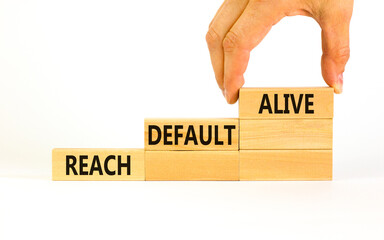 Reach default alive symbol. Concept words Reach default alive on wooden blocks on a beautiful white table white background. Businessman hand. Business, finacial and reach default alive concept.