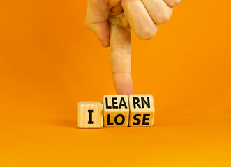 I learn or lose symbol. Concept words I learn and I lose on wooden cubes. Businessman hand. Beautiful orange table orange background. Business and i learn or lose concept. Copy space.