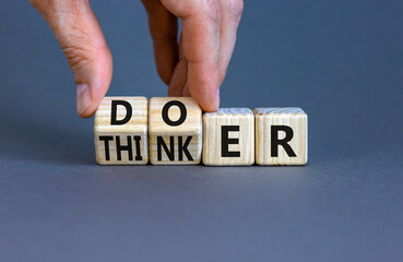 Doer or thinker symbol. Concept words Doer or thinker on wooden cubes. Businessman hand. Beautiful...