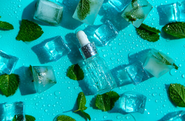 Bottle with cosmetics on a mint background with ice cubes and lemon. Selective focus.