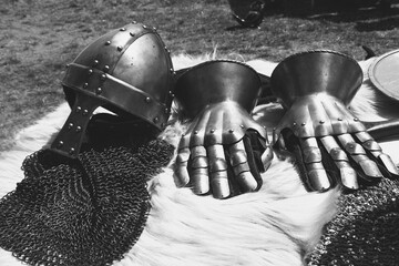 Knight helmet and gauntlets on fur. Middle ages armor still life background. Medieval festival...