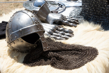 Knight helmet and gauntlets on fur. Middle ages armor still life background. Medieval festival...