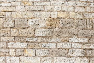ściana z kamienia w średniowiecznym klimacie  o bezowej kolorystyce. - obrazy, fototapety, plakaty
