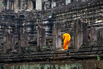 Ruins of temple at Angkor, with Buddhist monk on the right
