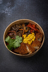 Japanese ramen soup with noodles, meat in a cardboard disposable plate
